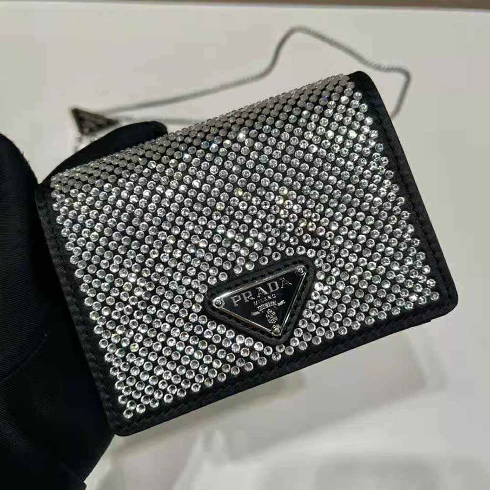 A rhinestone-covered cardholder with chain by Prada, 202…
