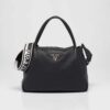 Prada Women Large Leather Handbag with the Prada Metal Lettering Logo Gleaming at Its Center-Black
